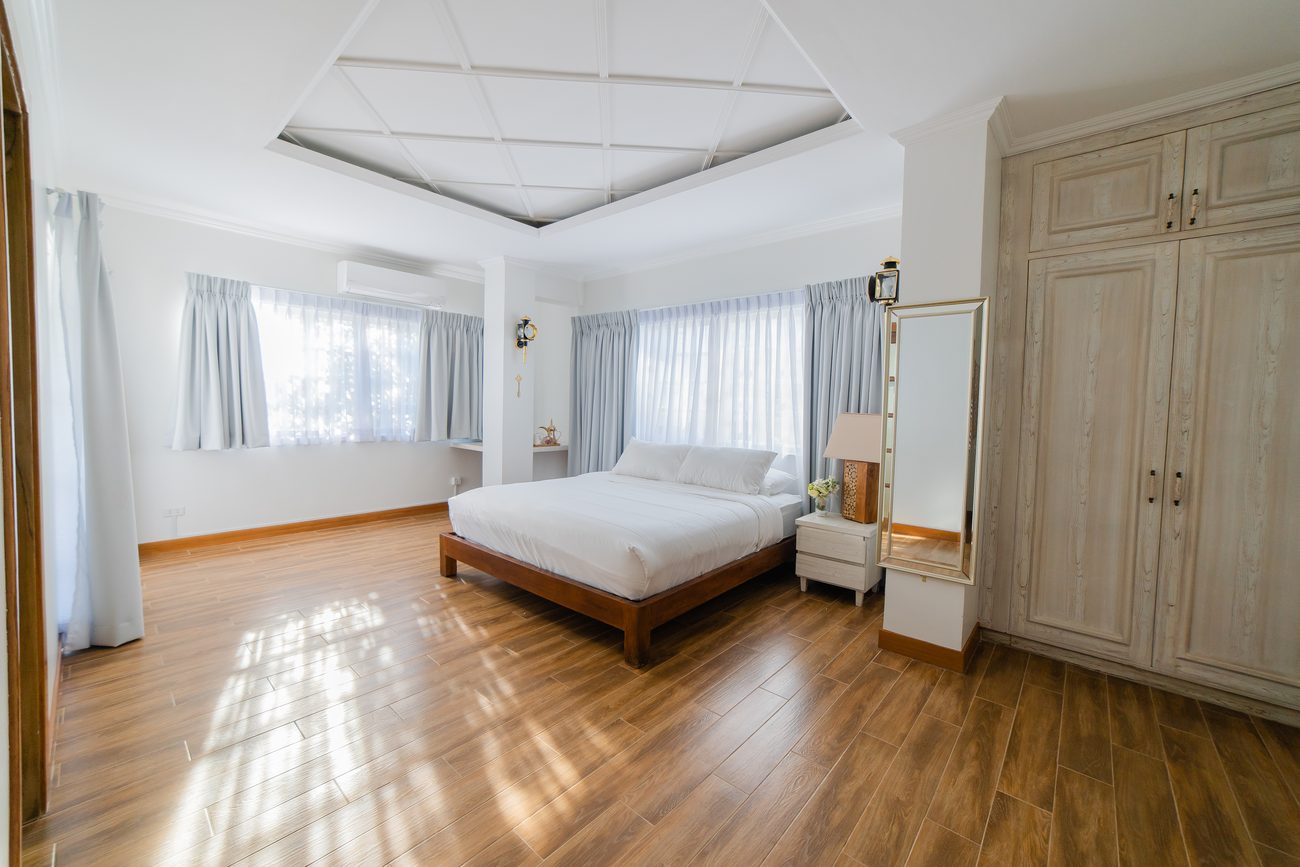 A light-filled guest room with warm wooden floors