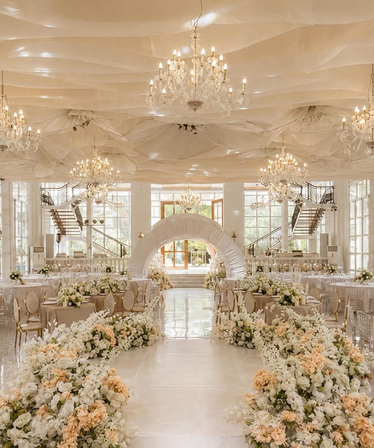 The hall at Somewhere by Casa beneath its twin staircases, dressed in white for a wedding