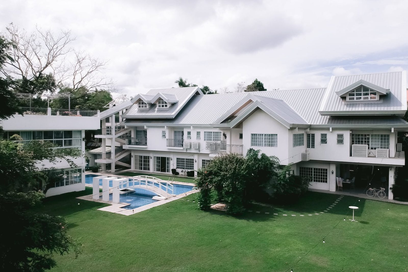 The pool and green lawn beside Casa's white house