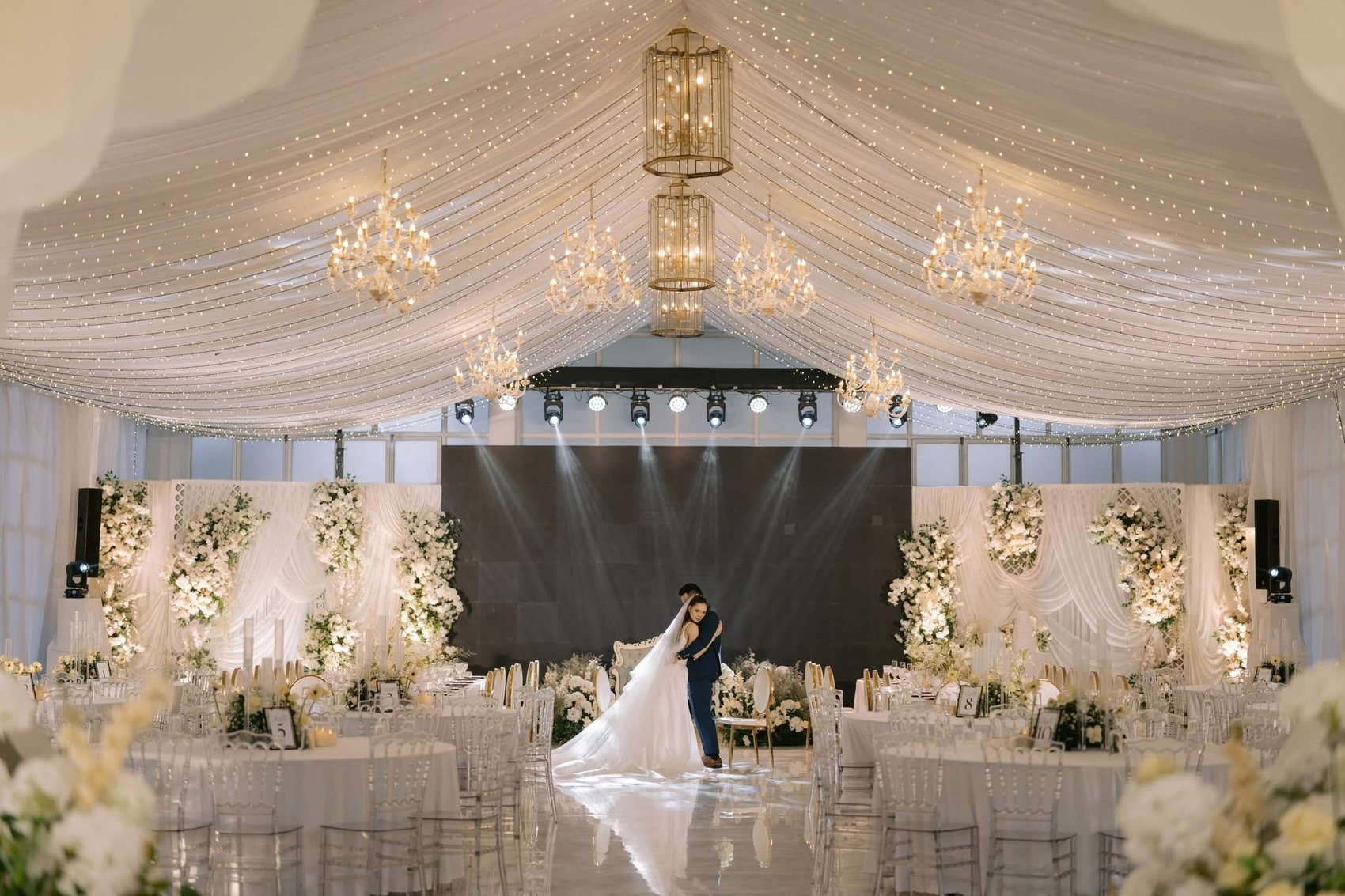 The draped ballroom at Casa de Canitoan beneath chandeliers and a canopy of fairy lights